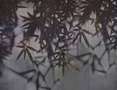 Dark palm leaves wall mural with a touch of gold on a tile